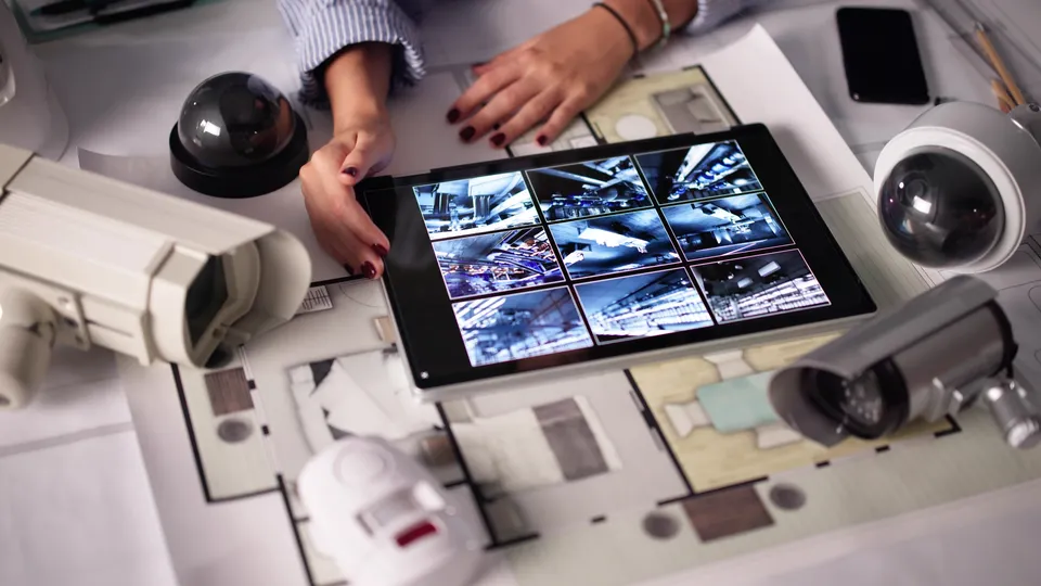 Hands with a tablet showing camera views