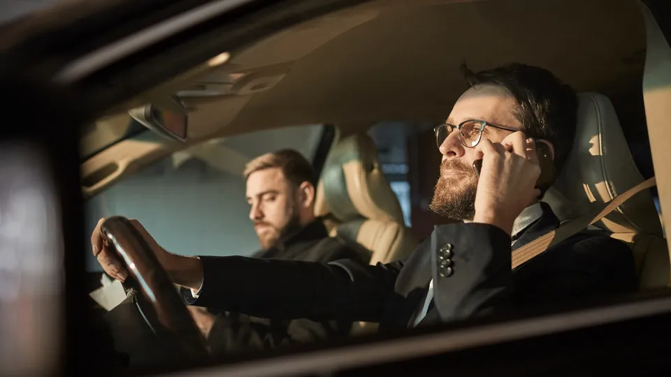 Deux collègues en voiture, le conducteur sourit