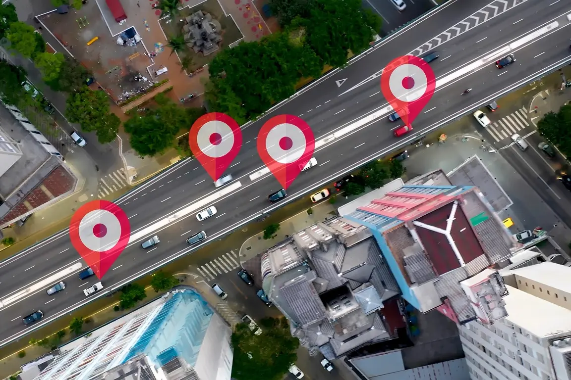 Aerial view of a city road with red location pins